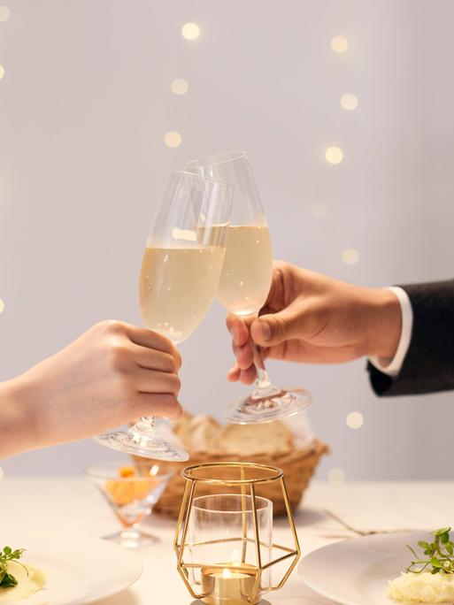 Mann und Frau stoßen mit Champagner an.