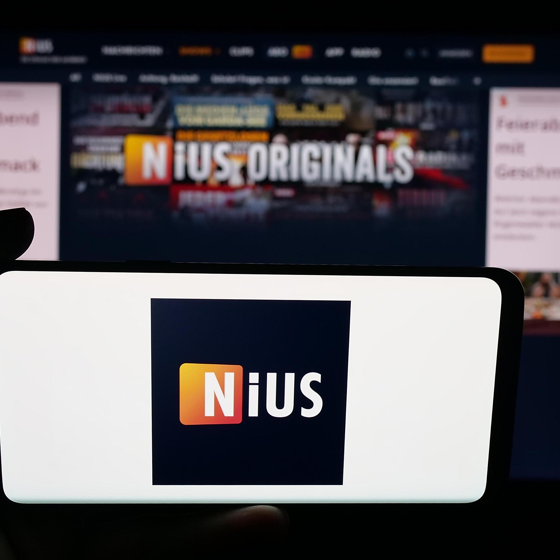 Im Hintergrund ein Bildschirm, im Vordergrund ein Handy mit dem Logo von Nius