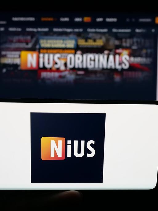 Im Hintergrund ein Bildschirm, im Vordergrund ein Handy mit dem Logo von Nius