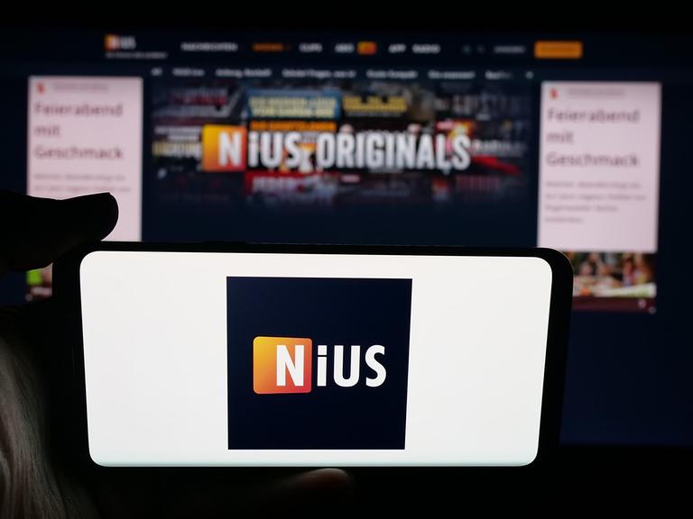 Im Hintergrund ein Bildschirm, im Vordergrund ein Handy mit dem Logo von Nius