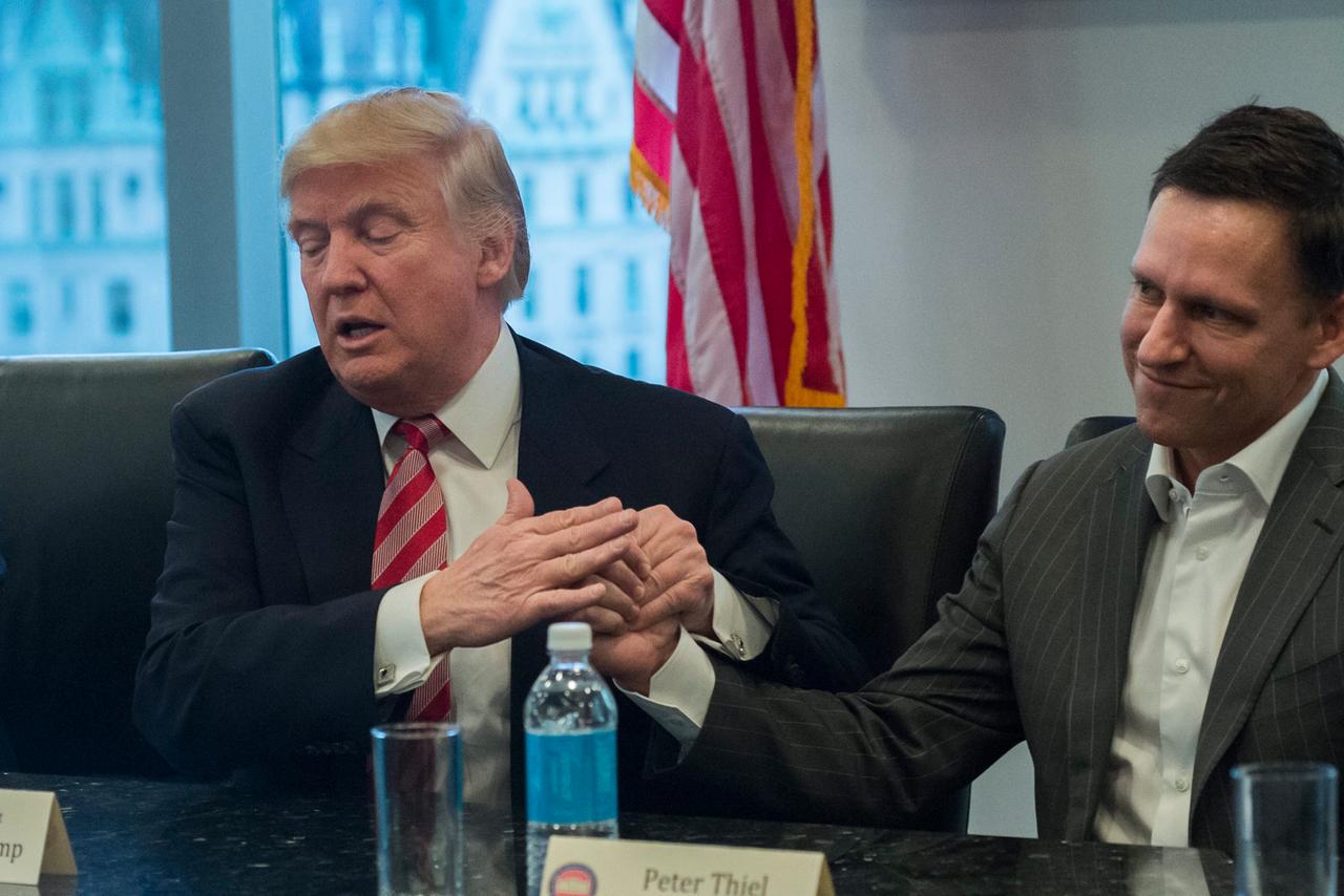 2016: Der künftige Präsident Donald Trump hält die Hand seines Unterstützers Peter Thiel. 2016: Der künftige Präsident Donald Trump hält die Hand seines Unterstützers Peter Thiel.