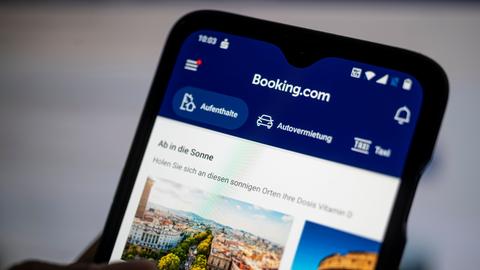 Auf einem Smartphone ist die App des Reiseportals Booking.com zu sehen. 