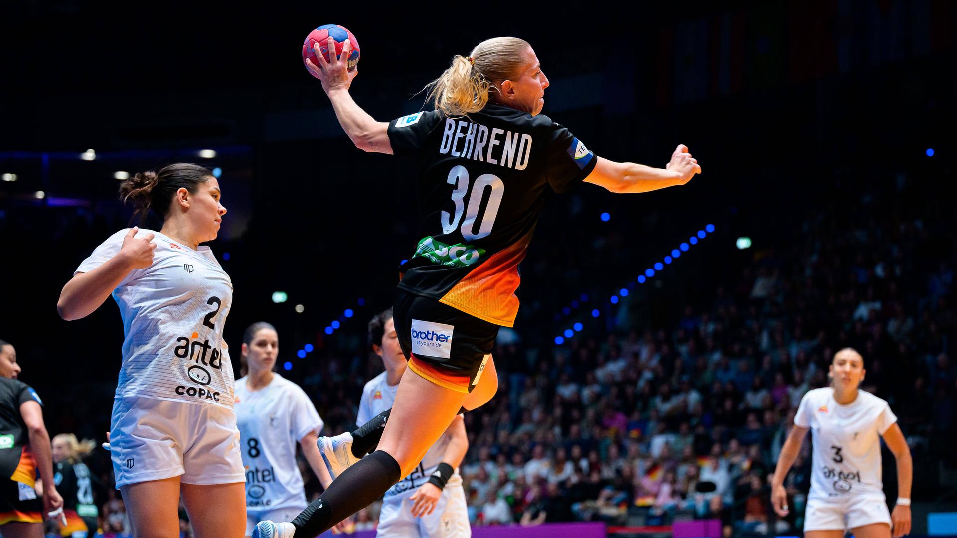 Die deutsche Handballerin Jenny Behrend springt hoch und wirft den Ball.
