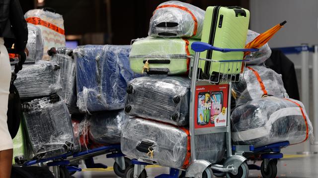 Reisekoffer stehen am Düsseldorfer Flughafen auf einem Trolley vor dem Check-In-Schalter. Die Koffer sind mit Folie geschützt. Reisekoffer stehen am Düsseldorfer Flughafen auf einem Trolley vor dem Check-In-Schalter. Die Koffer sind mit Folie geschützt.