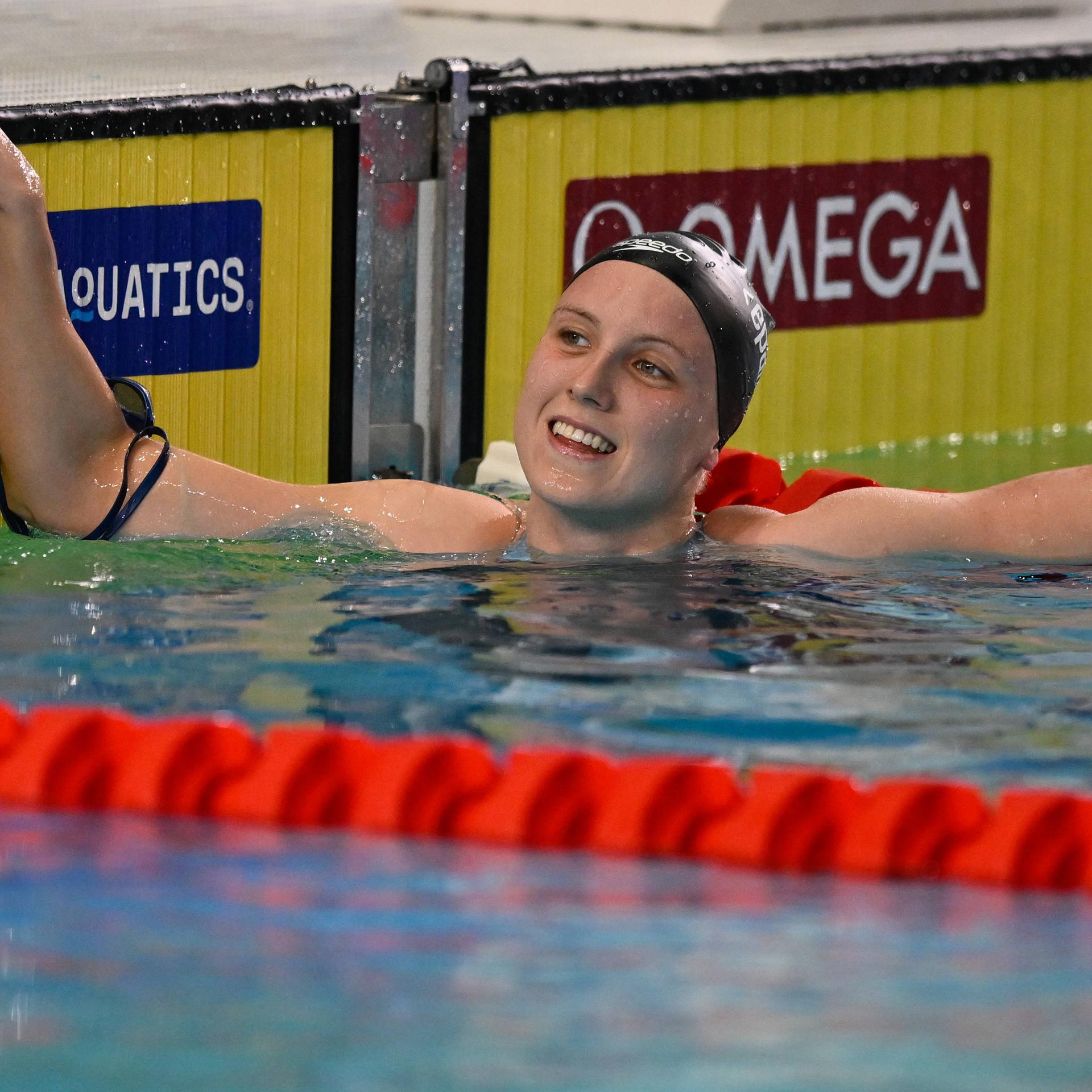 Schwimmerin Isabel Gose ist am Beckenrand im Wasser und freut sich.