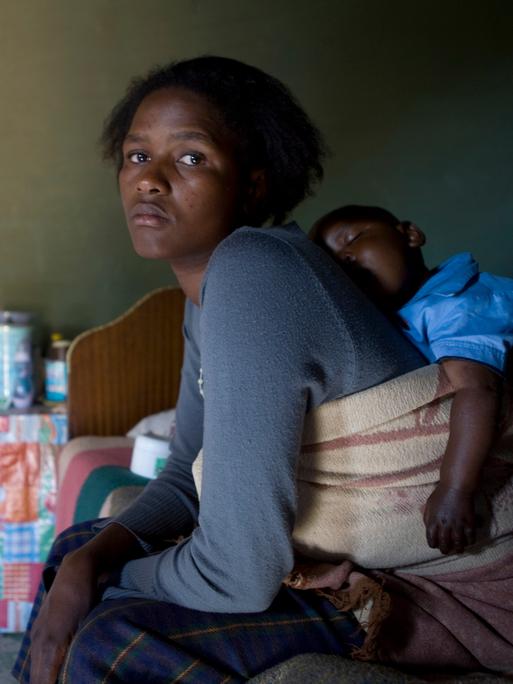 Mathato Notsi (29) ist nachdenklich gestimmt, nachdem sie ihrem zehn Monate alten Baby Mpho seine morgendliche Dosis antiretroviraler Medikamente gegeben hat. 
