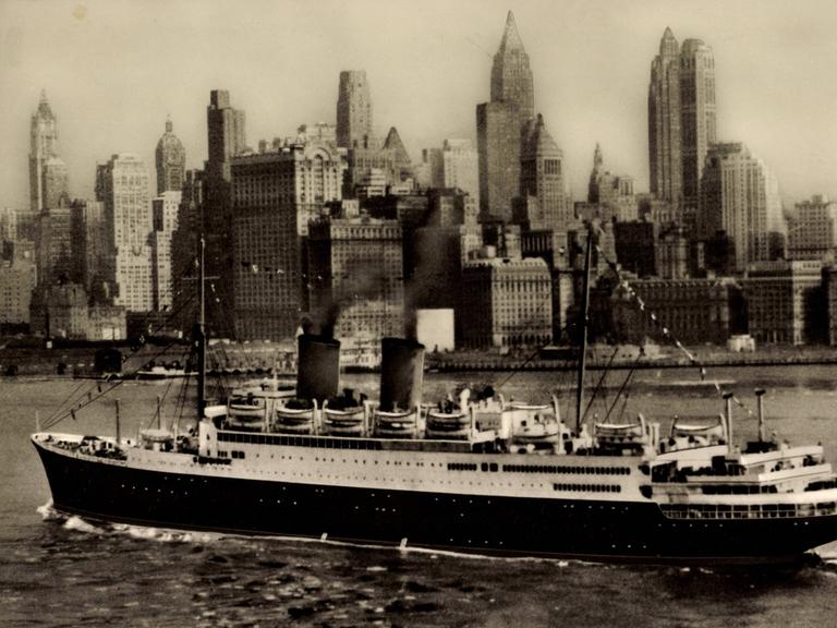 Historisches Schwarzweißfoto: Das Dampfschiff MS Berlin kreuzt vor der Silhouette New Yorks.