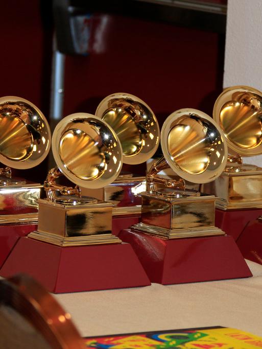 Sechs Grammys stehen auf einem Tisch.