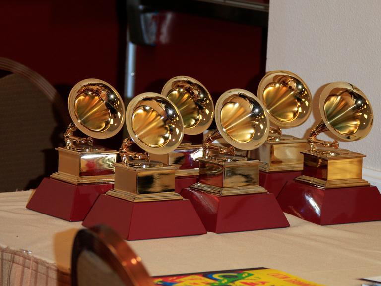 Sechs Grammys stehen auf einem Tisch.