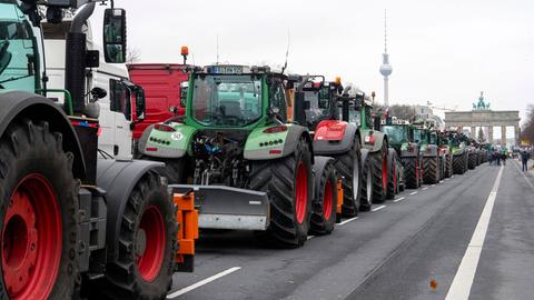 Traktoren stauen sich auf der Straße des 17. Juni in Berlin, im Hintergrund: Brandenburger Tor und Fernsehturm.