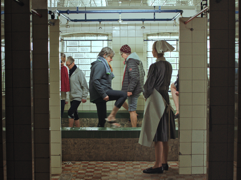 Eine Gruppe von Menschen beim "Wassertreten" im ehemaligen Kinderkurheim Johannaberg bei Detmold. Im Vordergrund eine Frau, die eine Schwesteruiform aus vergangenen Zeiten trägt
 Eine Gruppe von Menschen beim "Wassertreten" im ehemaligen Kinderkurheim Johannaberg bei Detmold. Im Vordergrund eine Frau, die eine Schwesteruiform aus vergangenen Zeiten trägt