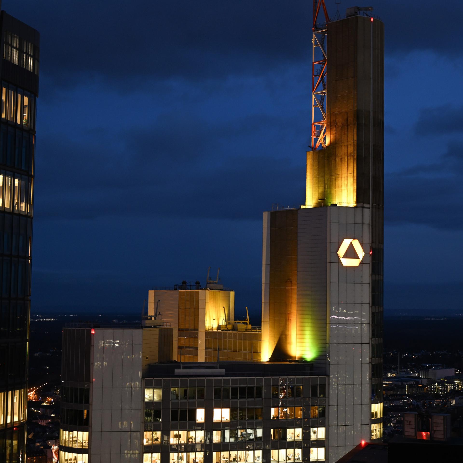 Das Unternehmenslogo leuchtet bei Sonnenuntergang auf der Zentrale der Commerzbank.