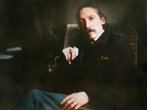 Ein Mann mittleren Alters mit Schnurrbart und Zigarette in der Hand blickt direkt in die Kamera.