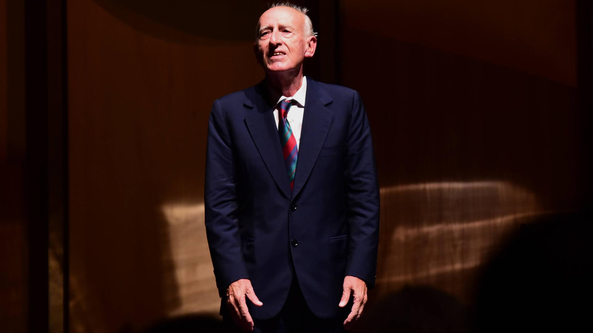 Der Dirigent Maurizio Pollini steht auf einer Bühne. Der Dirigent Maurizio Pollini steht auf einer Bühne.