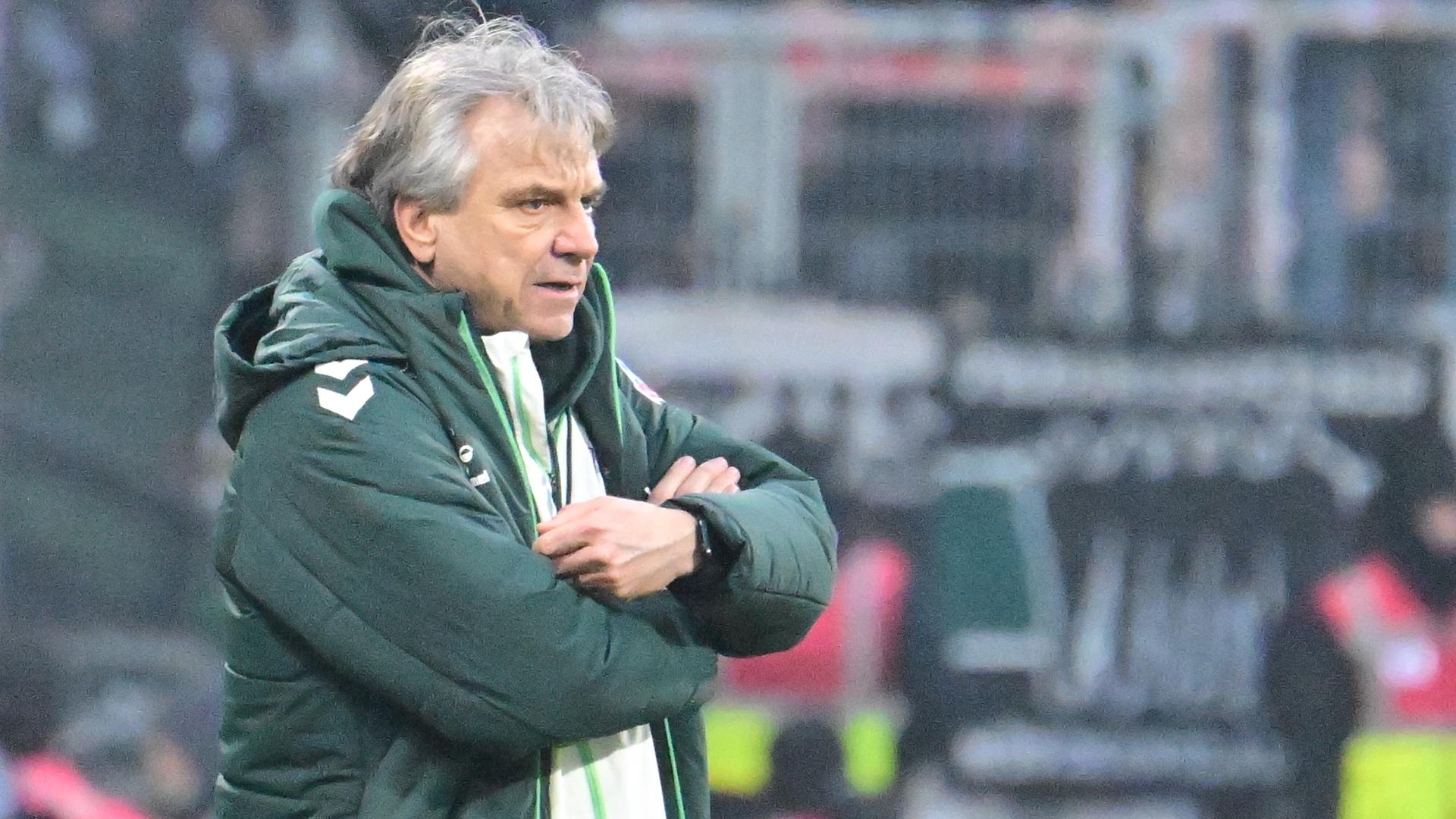 Horst Steffen steht in Jacke am Spielfeldrand.