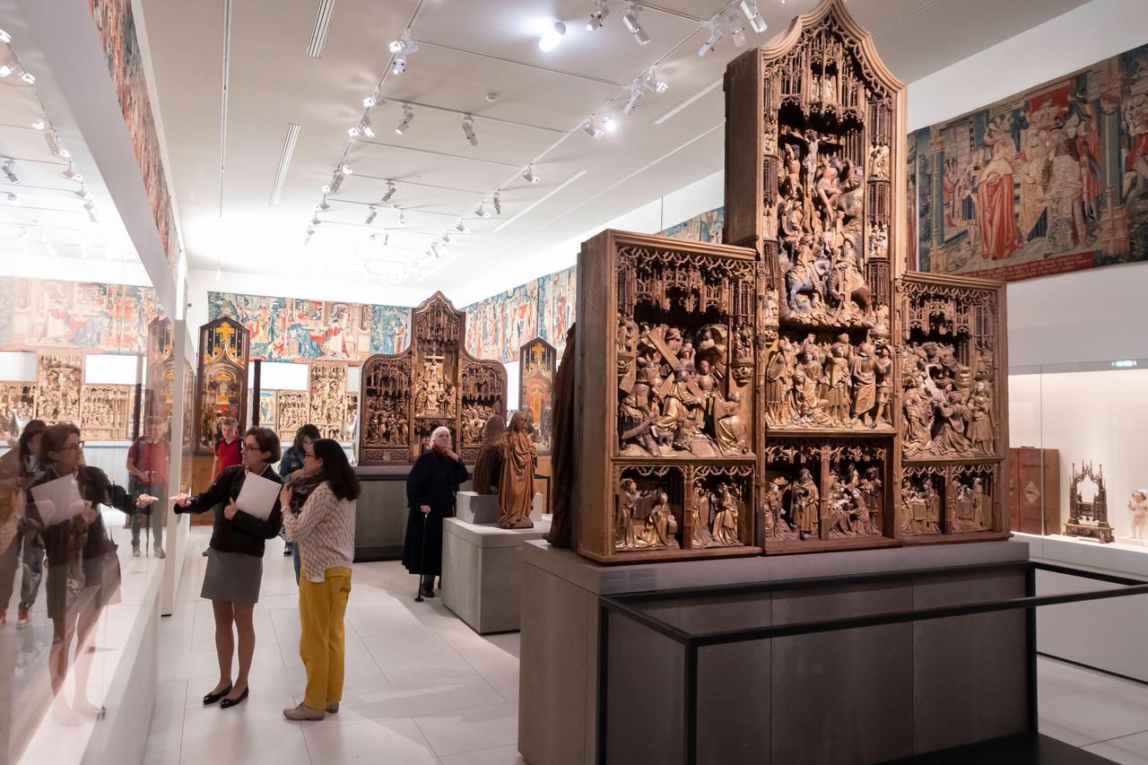 Besucher im Musée de Cluny betrachten Kunstwerke des Mittelalters.