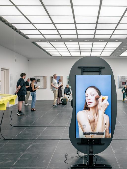 Besucher in der Ausstellung "Fake Views" der Medienkünstler Eva und Franco Mattes im Frankfurter Kunstverein. Verschiedene Installationen sind auf Flachbildschirmen zu sehen.