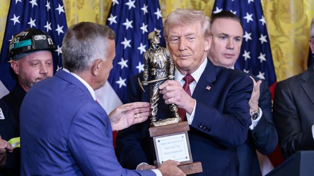 US-Präsident Donald Trump hält die Auszeichnung "Champion of Coal" in der Hand, die einen Kohlearbeiter zeigt. Neben ihm steht der CEO des Kohlekonzerns "Peabody Energy" Jim Grech.
