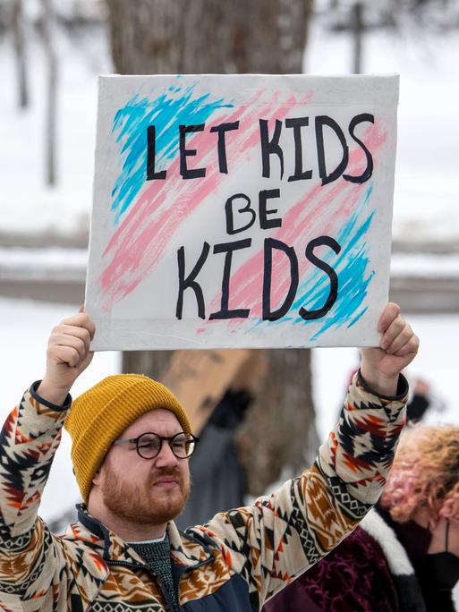 Demonstrant in Minnesota, USA, mit einem Schild "Let Kids be Kids" bei einer Demonstation für die Rechte von Trans-Jugendlichen