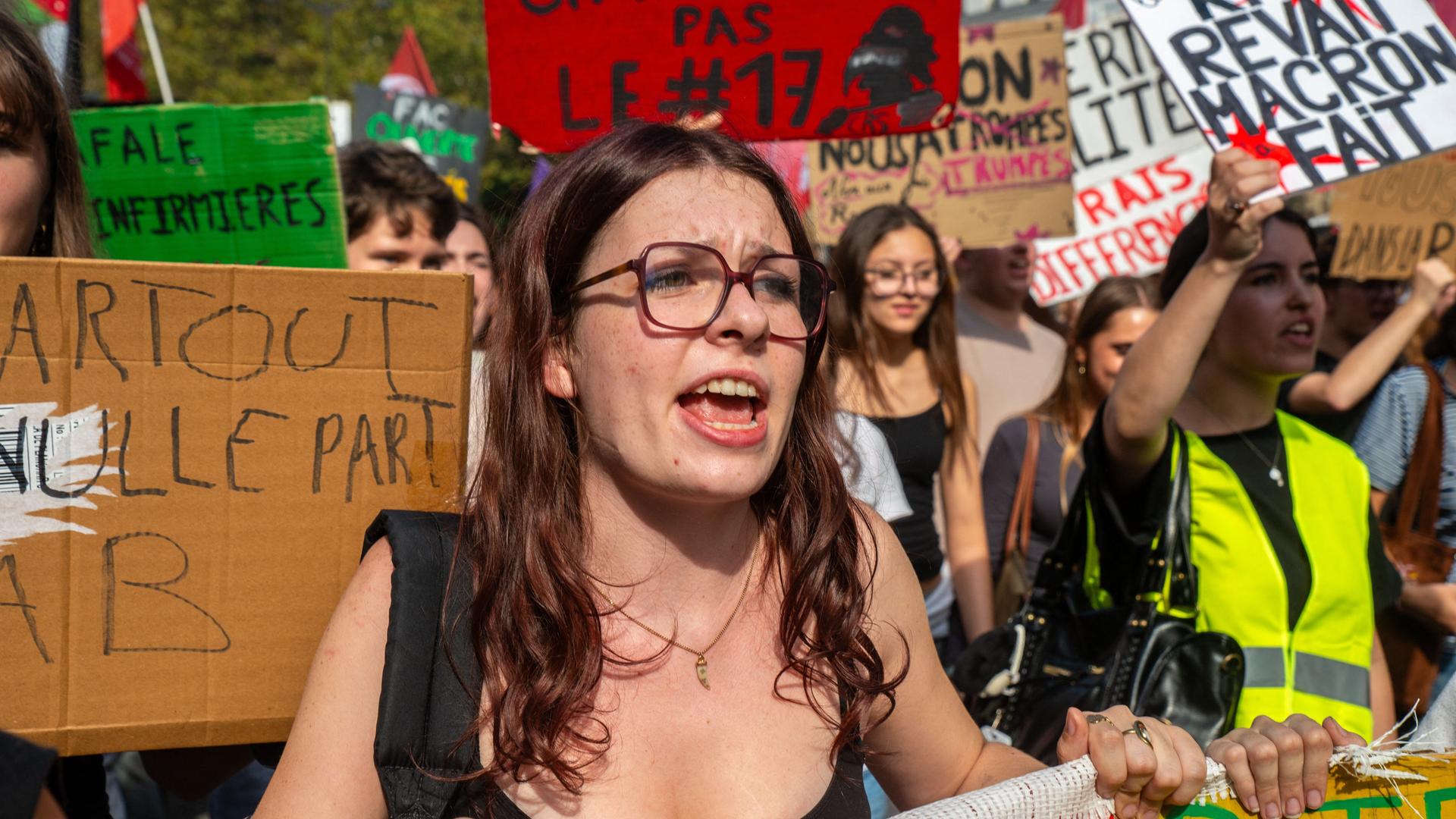 Junge Demonstrantinnen und Demonstranten halten Banner und Plakate in den Händen. 