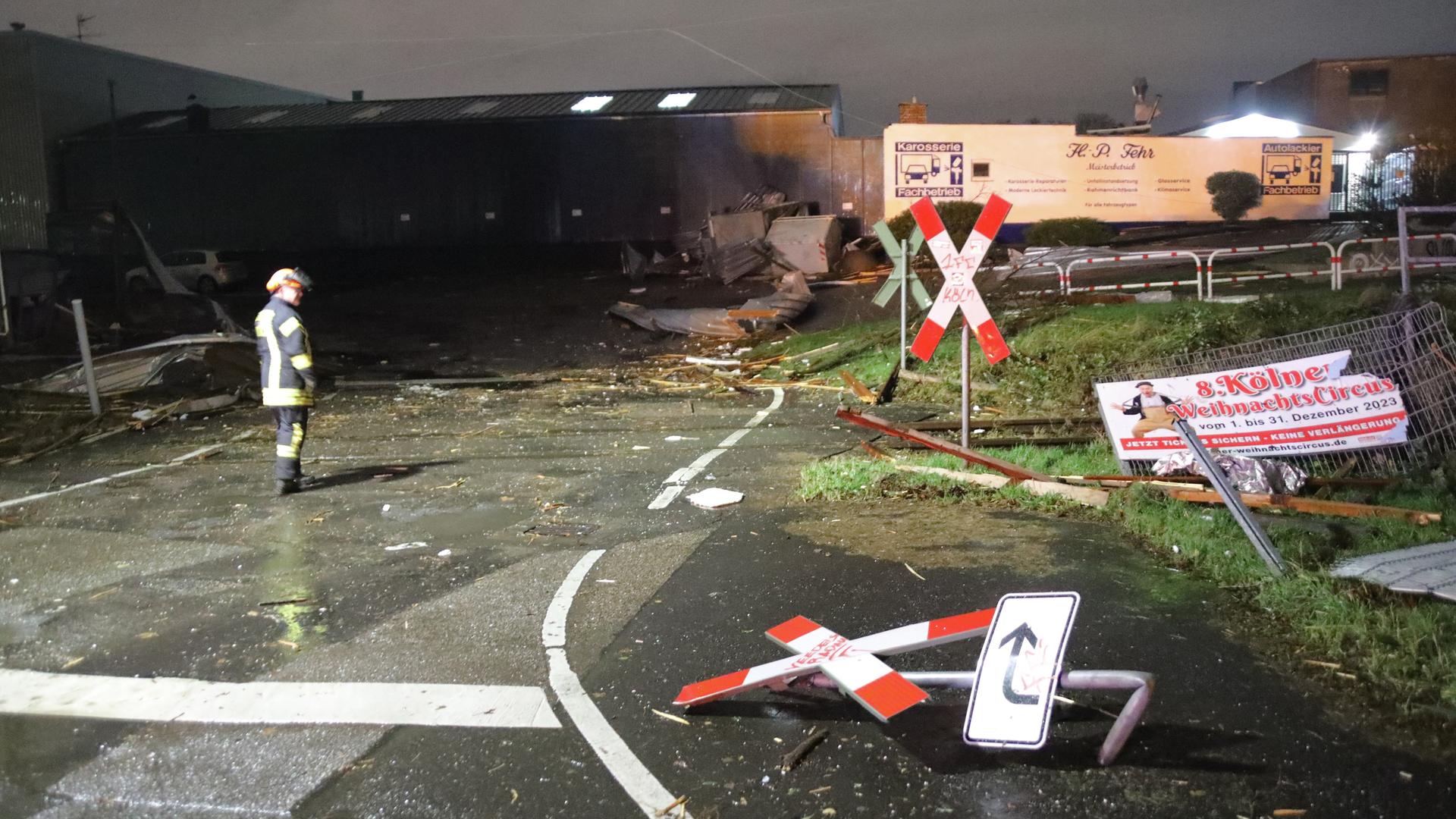 Ein Feuerwehrmann betrachtet die Trümmer und Schäden durch Sturmtief "Zoltan" an einem Bahnübergang in Köln. Ein Feuerwehrmann betrachtet die Trümmer und Schäden durch Sturmtief "Zoltan" an einem Bahnübergang in Köln.
