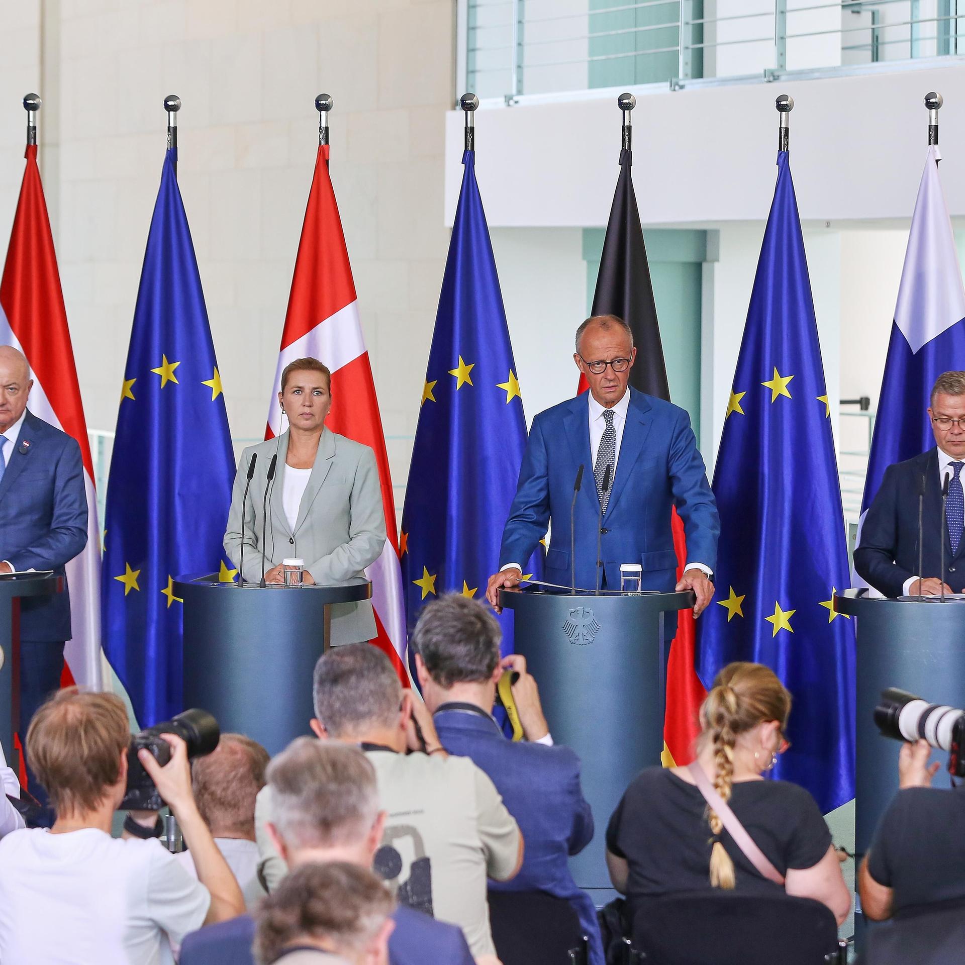 Bundeskanzleramt: Christian Stocker (Österreich), Mette Frederiksen (Dänemark), Bundeskanzler Friedrich Merz (CDU) (Deutschland), Petteri Orpo (Finnland) stehen nebeneinander an Rednerpulten, vor ihnen Journalisten.
