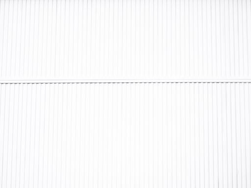 Mensch sitzt alleine auf Mauer. 