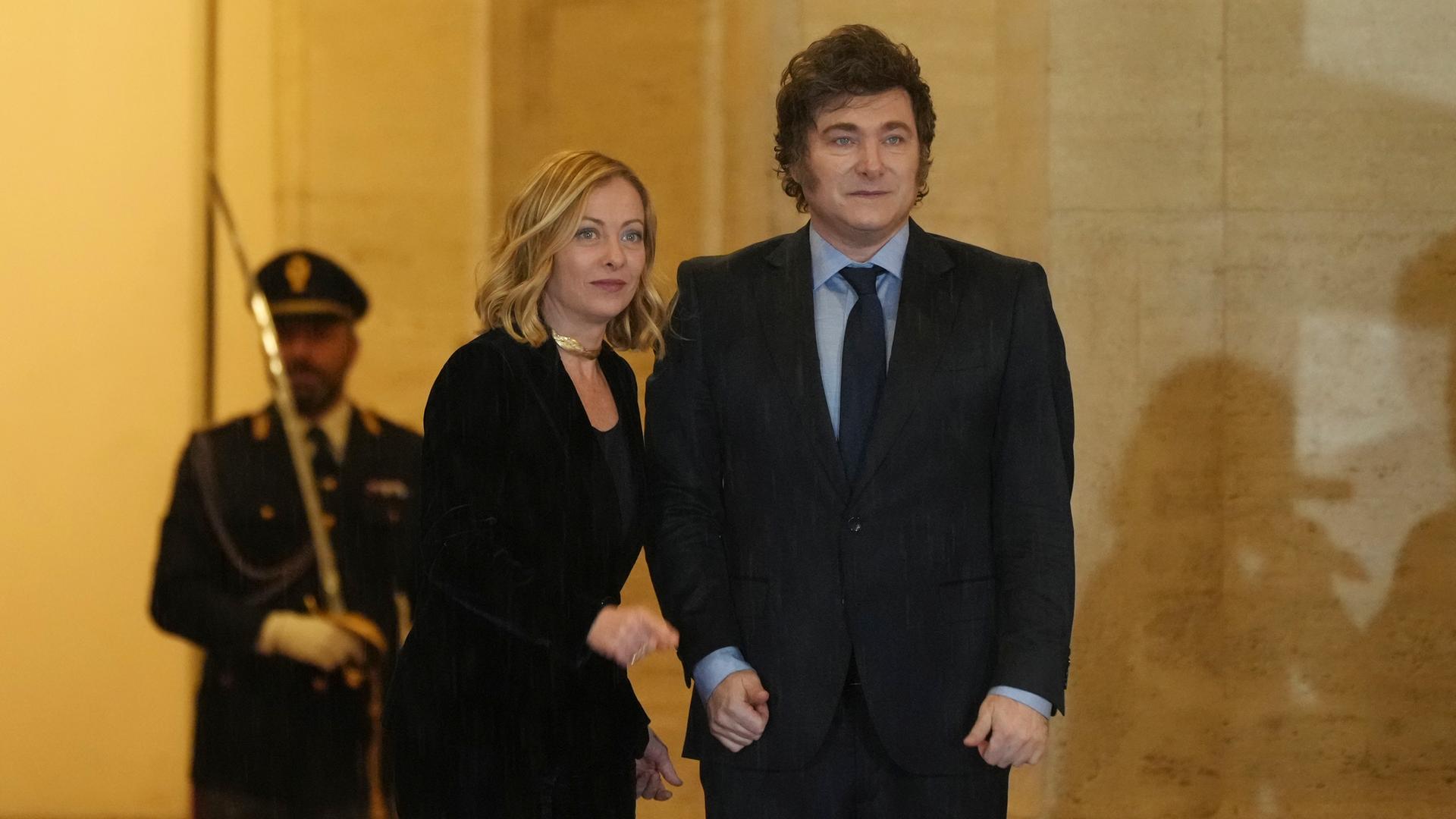 Die italienische Regierungschefin Meloni und der argentinische Präsident Milei stehen eng nebeneinander. Im Hintergrund ist ein Soldat zu sehen. Die italienische Regierungschefin Meloni und der argentinische Präsident Milei stehen eng nebeneinander. Im Hintergrund ist ein Soldat zu sehen.
