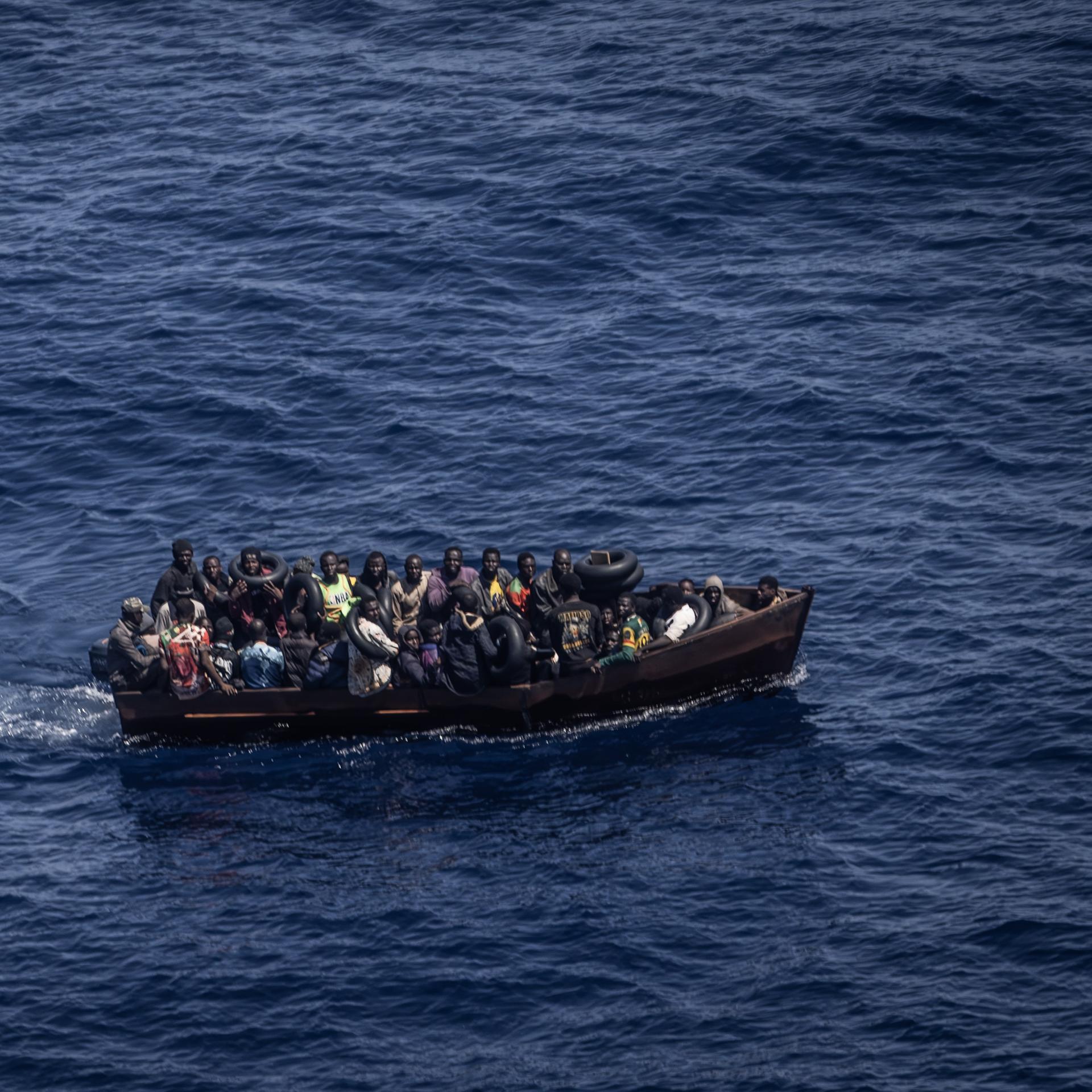 Migranten steuern ein Boot von der Nordküste Afrikas über das Mittelmeer in Richtung der italienischen Insel Lampedusa. Von Tunesien aus setzen immer mehr afrikanische Flüchtlinge nach Italien über. Viele Migranten zahlen für die Reise nicht nur finanziell einen hohen Preis.
