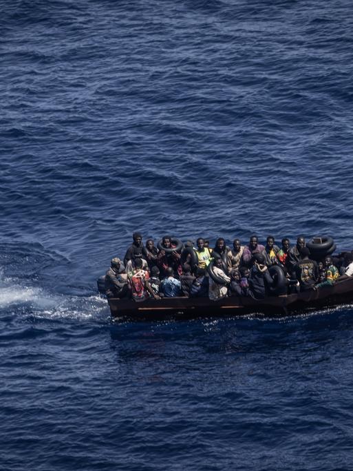 Migranten steuern ein Boot von der Nordküste Afrikas über das Mittelmeer in Richtung der italienischen Insel Lampedusa. Von Tunesien aus setzen immer mehr afrikanische Flüchtlinge nach Italien über. Viele Migranten zahlen für die Reise nicht nur finanziell einen hohen Preis.