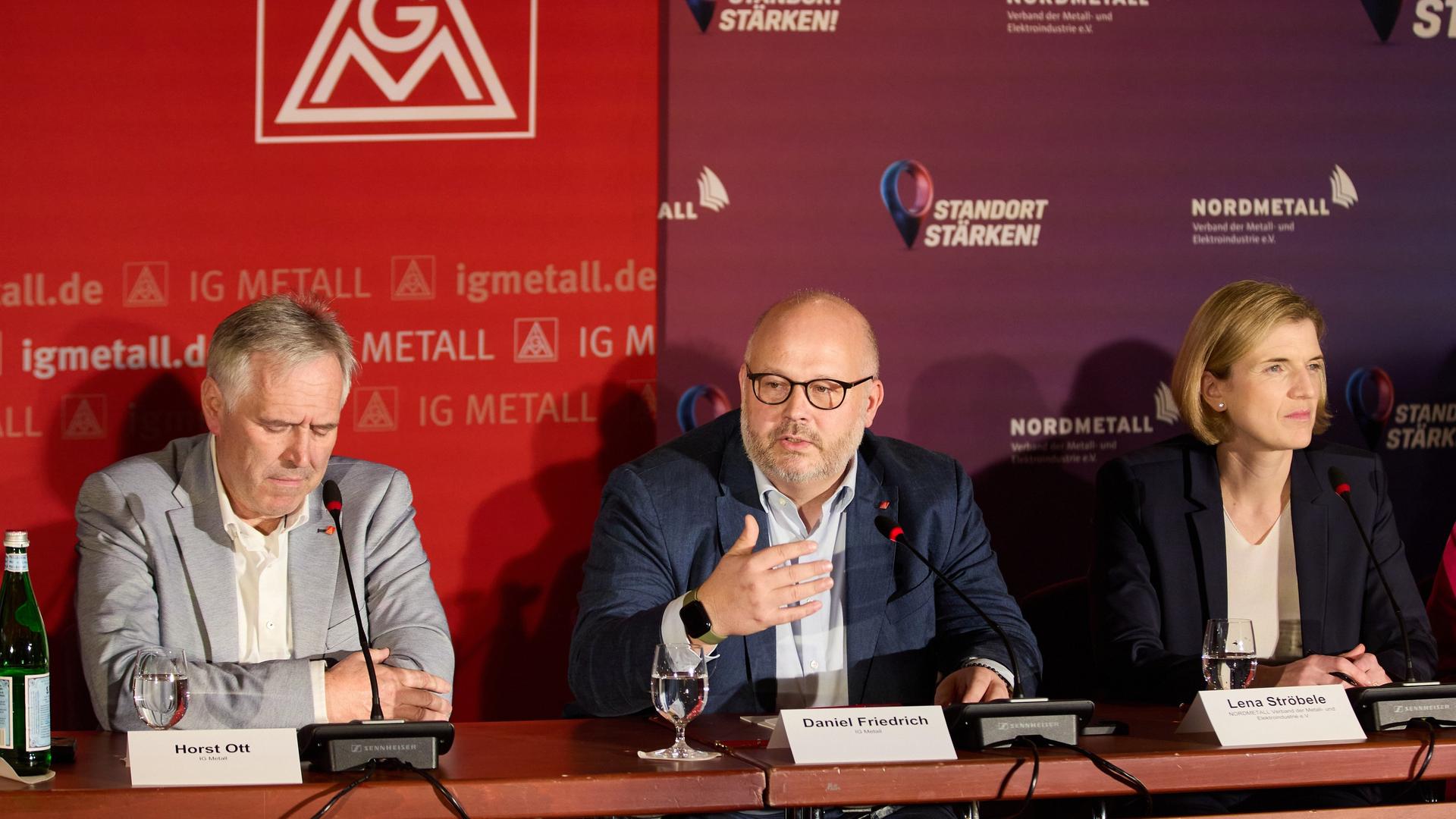 Daniel Friedrich (M), Verhandlungsführer IG Metall Küste, verkündet neben Horst Ott (l), Verhandlungsführer IG Metall Bayern, und Lena Ströbele (r), Verhandlungsführerin Nordmetall, auf einer Pressekonferenz die Einigung in den Tarifverhandlungen.