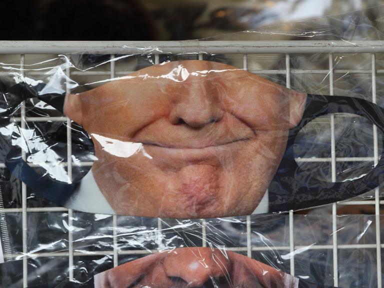 Atemschutzmaske mit dem Gesicht des ehemaligen US-Präsidenten Donald Trump