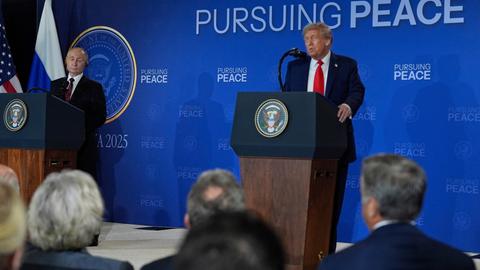 US-Präsident Trump und Russlands Präsident Putin stehen während einer Pressekonferenz an Redepulten, Trump spricht, Putin hört zu.