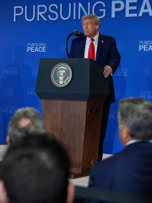 US-Präsident Trump und Russlands Präsident Putin stehen während einer Pressekonferenz an Redepulten, Trump spricht, Putin hört zu.