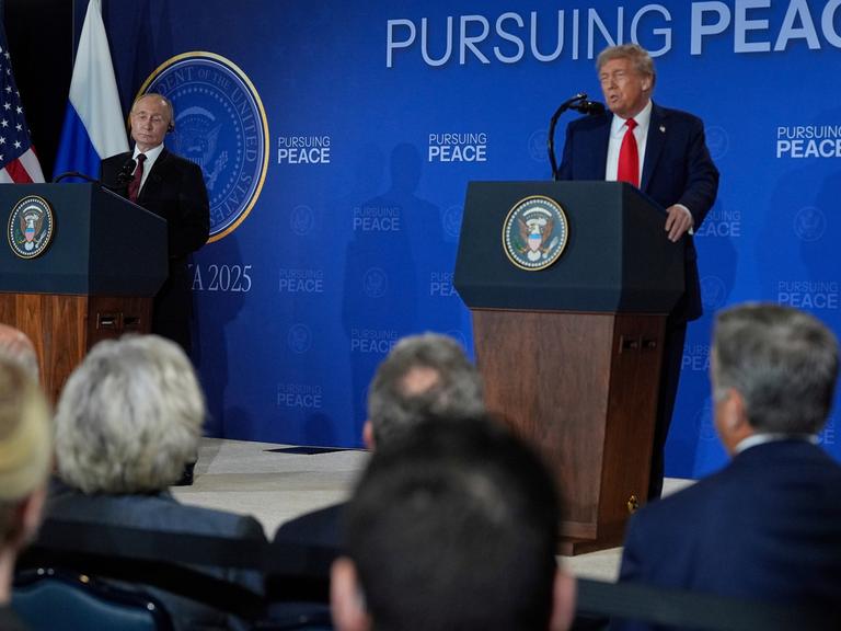 US-Präsident Trump und Russlands Präsident Putin stehen während einer Pressekonferenz an Redepulten, Trump spricht, Putin hört zu.