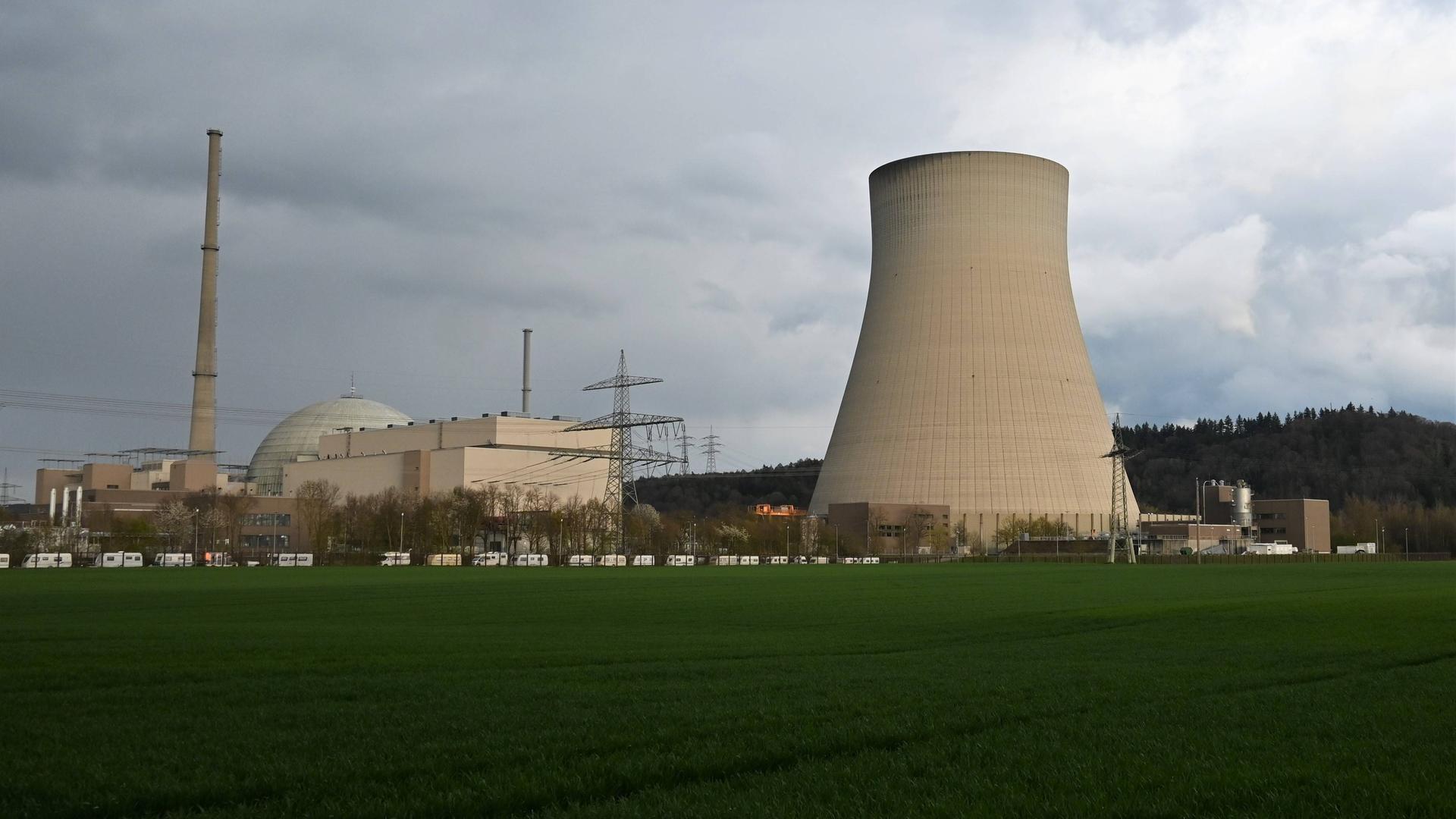 In grüner Landschaft steht der Kühlturm eines Atomkraftwerks. 