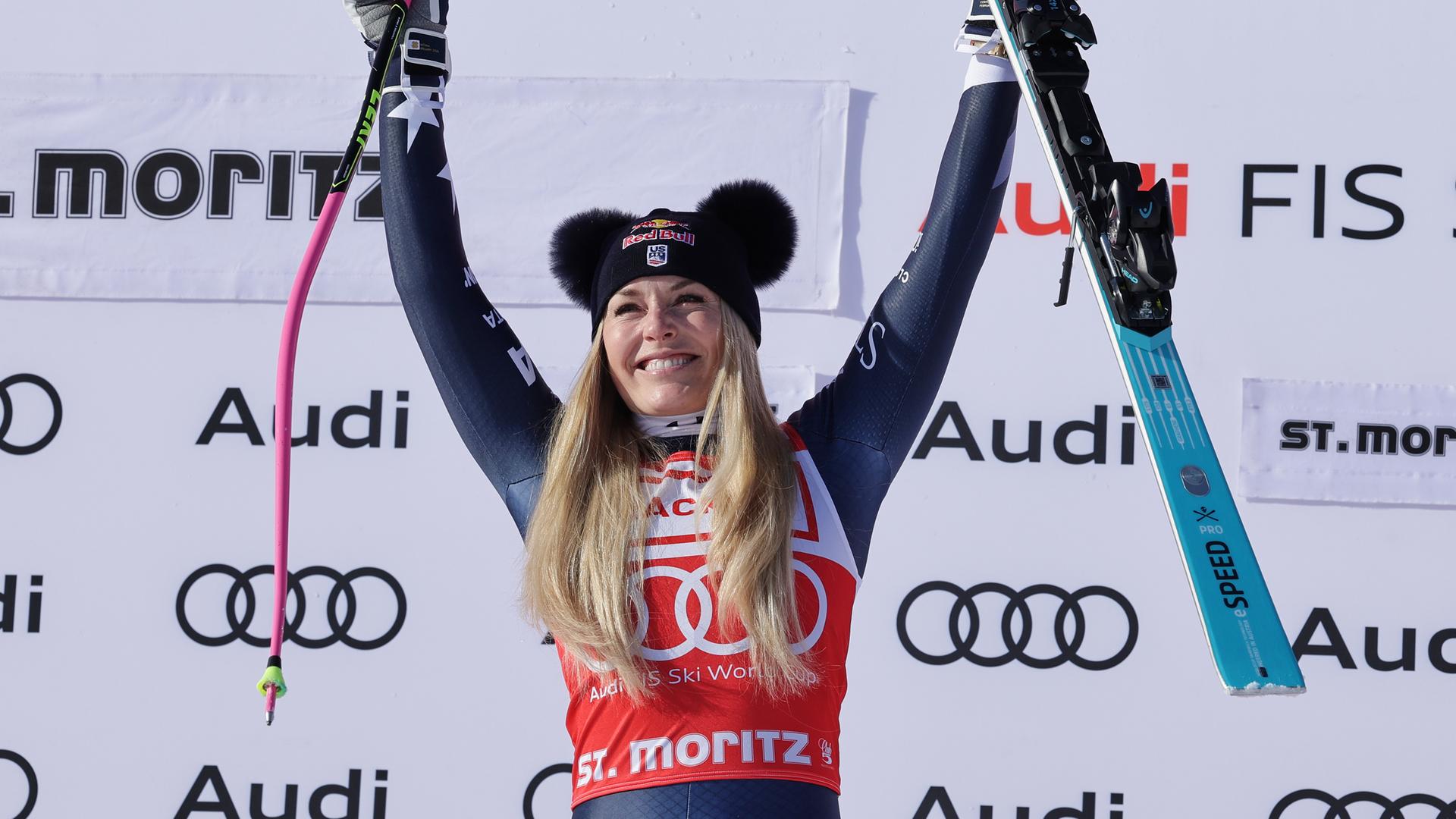 Lindsey Vonn hält einen Skistock und eine Skier hoch und jubelt. Lindsey Vonn hält einen Skistock und eine Skier hoch und jubelt.