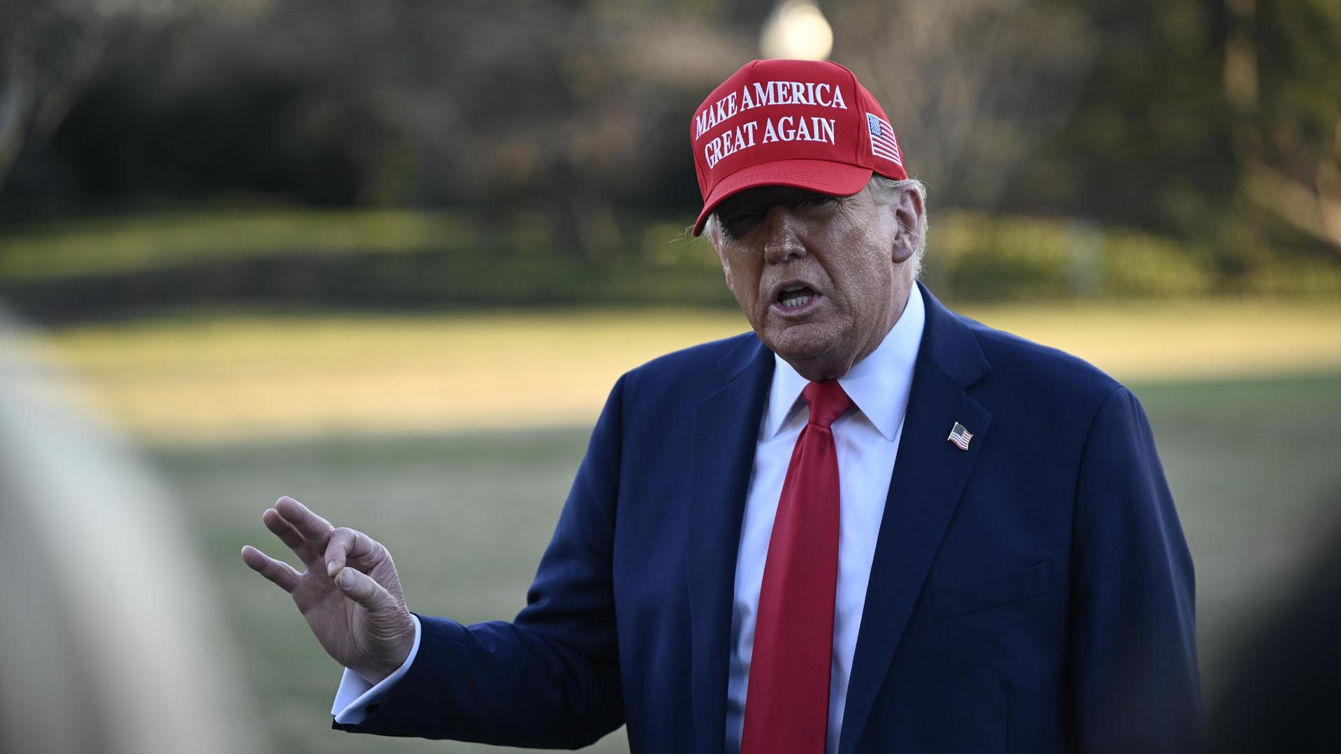 Donald Trump mit seiner roten "Make America Great Again" Kappe auf dem Rasen vor dem weißen Haus.