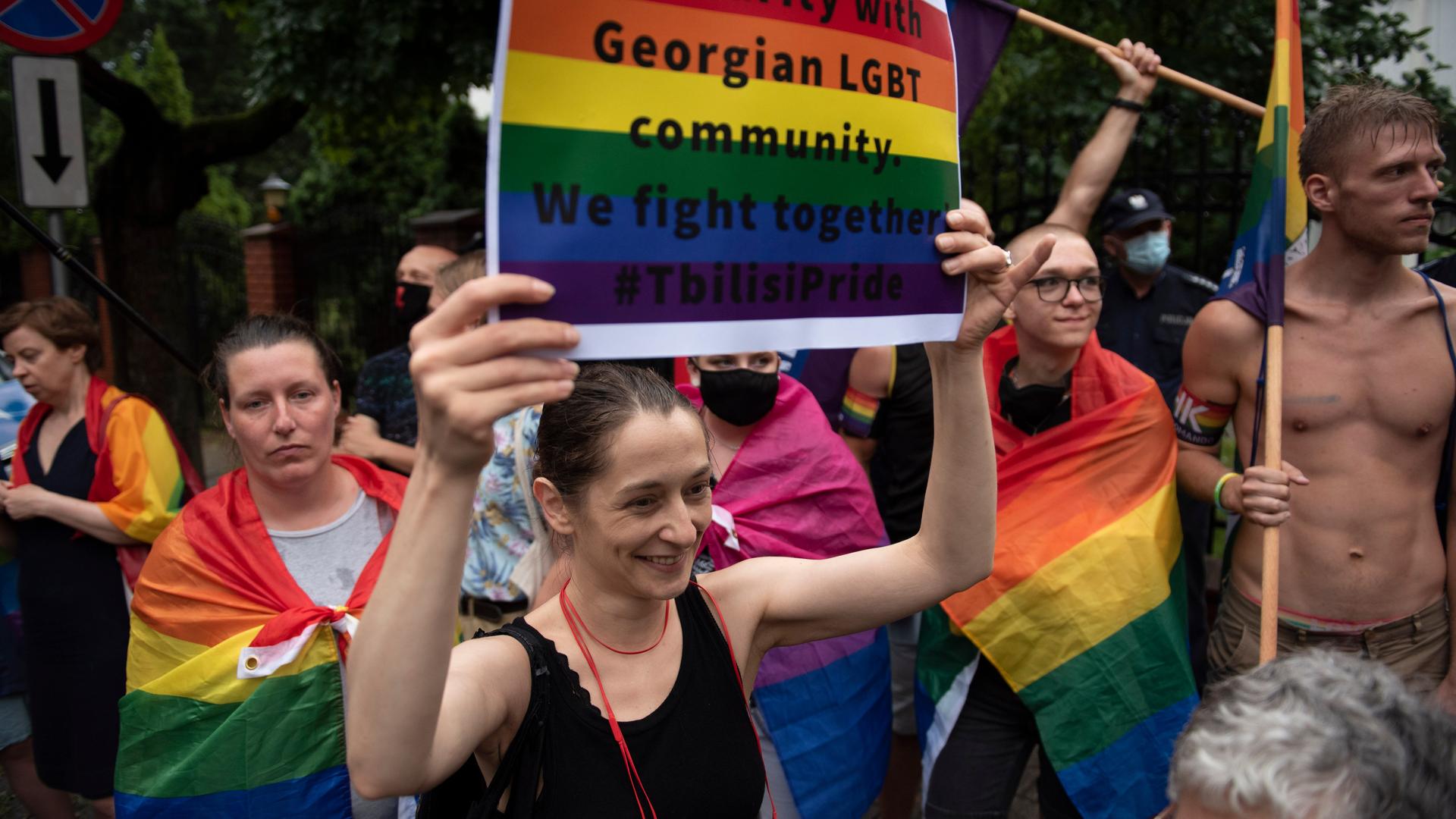 Eine Frau hält ein Schild in Regenbogenfarben in die Höhe, auf dem zu lesen ist: Solidarity with georgian LGBT community. We fight together.