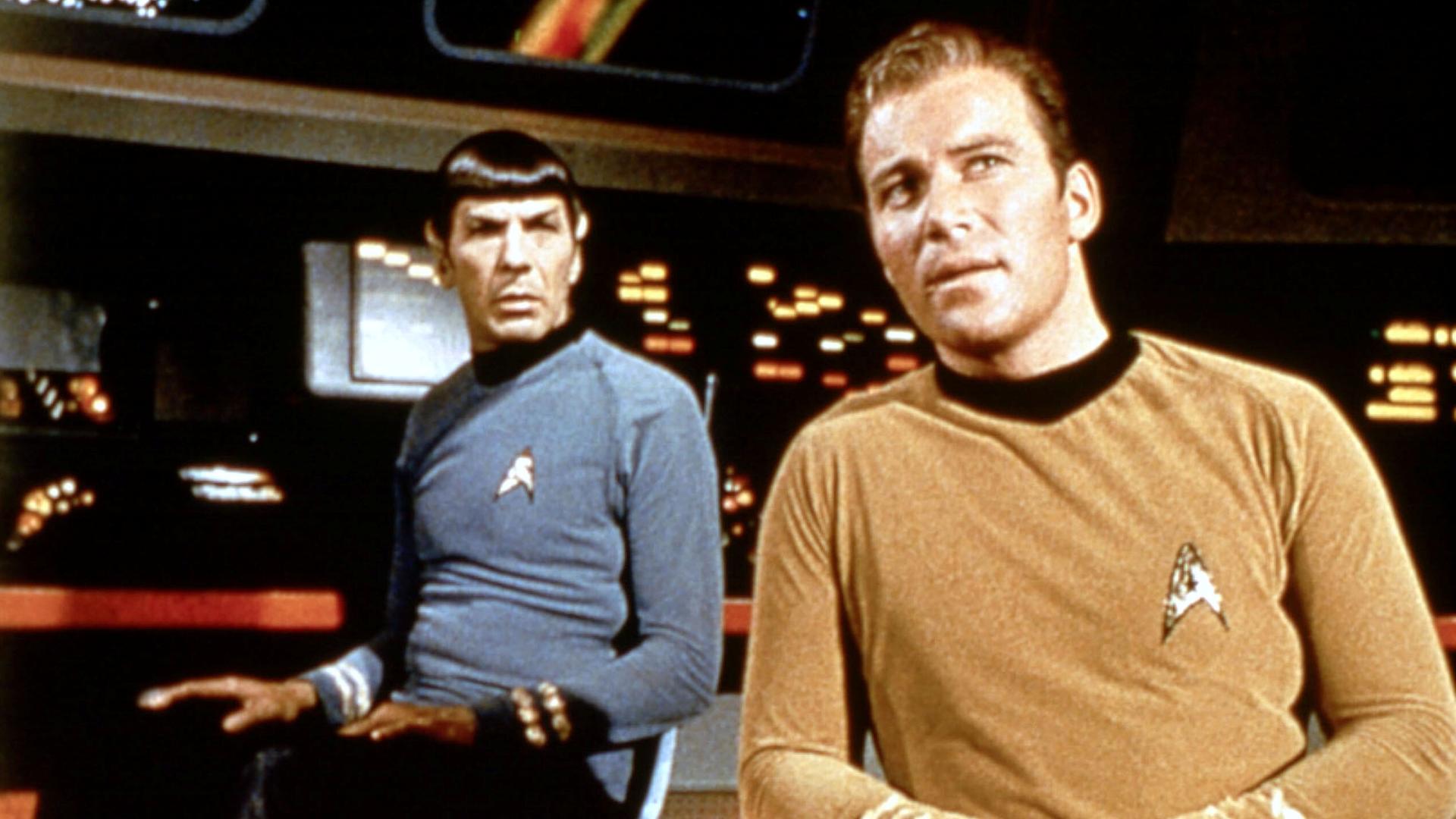 Aufnahme aus der Serie Star Trek. Zwei Schauspieler stehen in einer futuristischen Umgebung. Des sind Mr. Spock und Captain Kirk. 