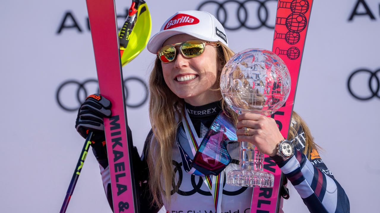Mikaela Shiffrin mit der Trophäe in der Hand. Sie lächelt.