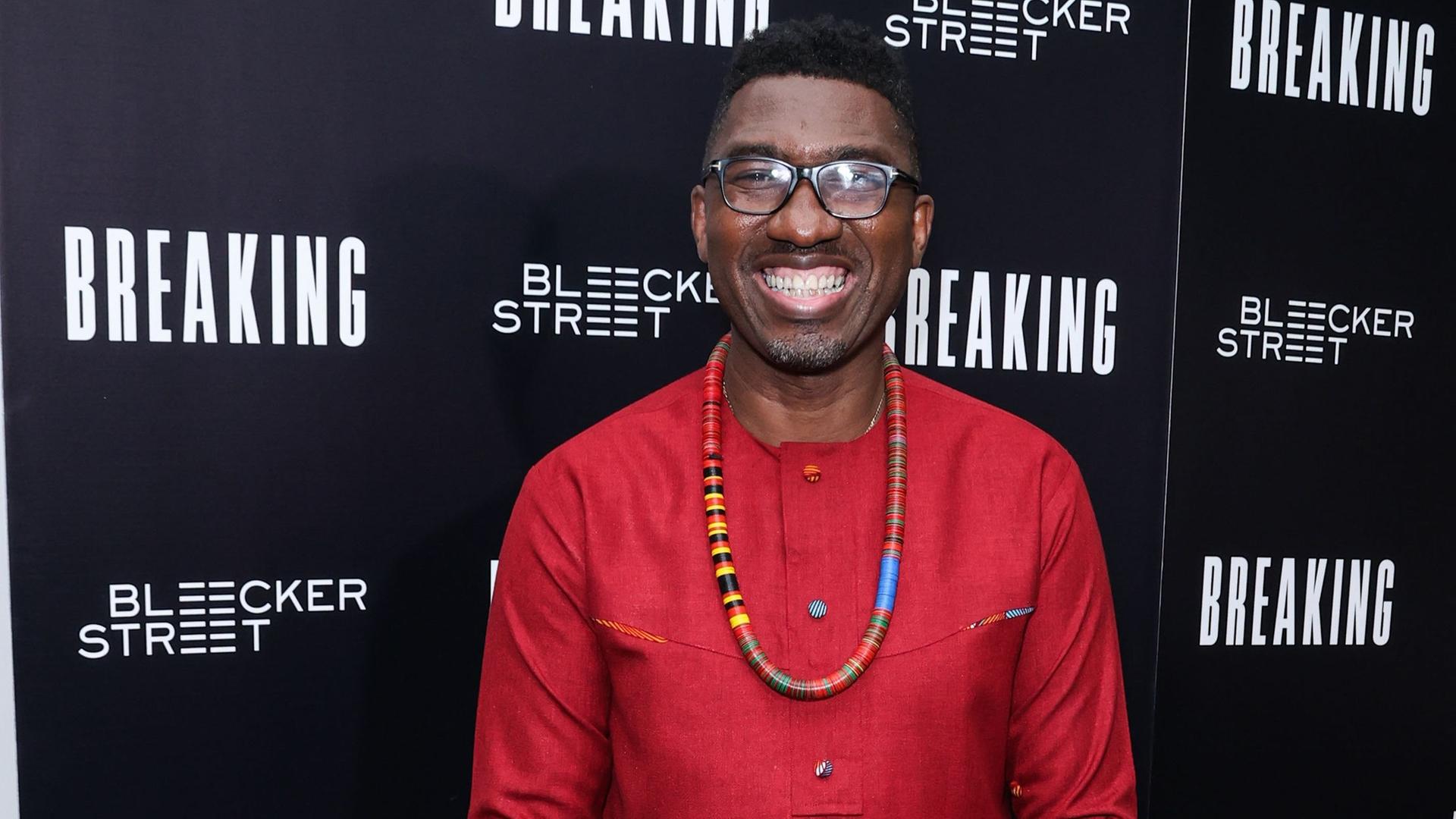 Kwame Kwei-Armah bei einer Filmpremiere in den USA vor einer Werbewand. 