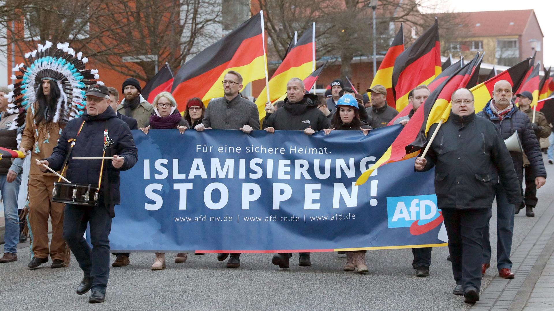 Menschen mit Deutschlandflaggen und einem Transparent mit dem Schriftzug "Islamisierung stoppen!": AfD-Demonstration 2019 gegen den Bau einer Moschee in Rostock.