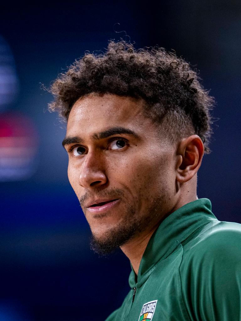 Ein Mann mit dunklen Locken und grünem Sportdress schaut ernst aus dem Bild hinaus. Ein Mann mit dunklen Locken und grünem Sportdress schaut ernst aus dem Bild hinaus.