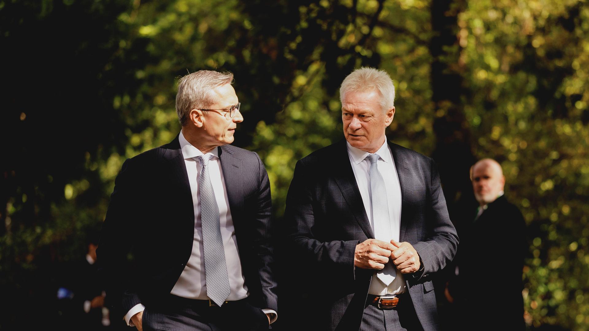 Karsten Wildberger, Bundesminister für Digitalisierung und Staatsmodernisierung (links) und Alois Rainer CSU, Bundesminister für Landwirtschaft, Ernaehrung und Heimat (rechts) laufen nebeneinenader her. Im Hintergrund ist Wald zu sehen. 