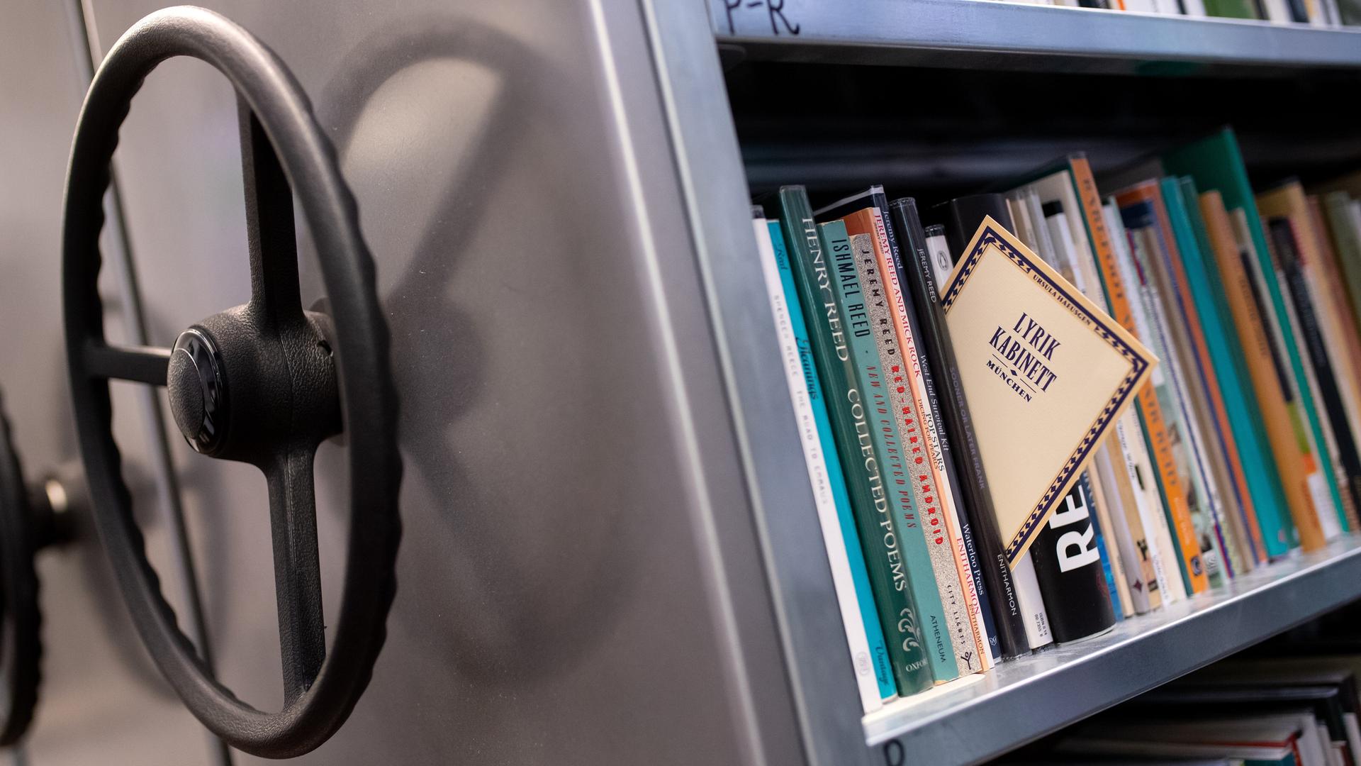 Ein Bucharchiv, das sich mittels Drehrad bewegen lässt. Aus den Büchern ragt ein Buch heraus, auf dem "Lyrik Kabinett" steht. Ein Bucharchiv, das sich mittels Drehrad bewegen lässt. Aus den Büchern ragt ein Buch heraus, auf dem "Lyrik Kabinett" steht.