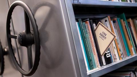 Ein Bucharchiv, das sich mittels Drehrad bewegen lässt. Aus den Büchern ragt ein Buch heraus, auf dem "Lyrik Kabinett" steht. 