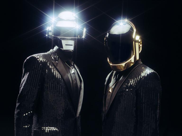 Die Musiker von Daft Punk in typischer Pose mit Robotermasken.