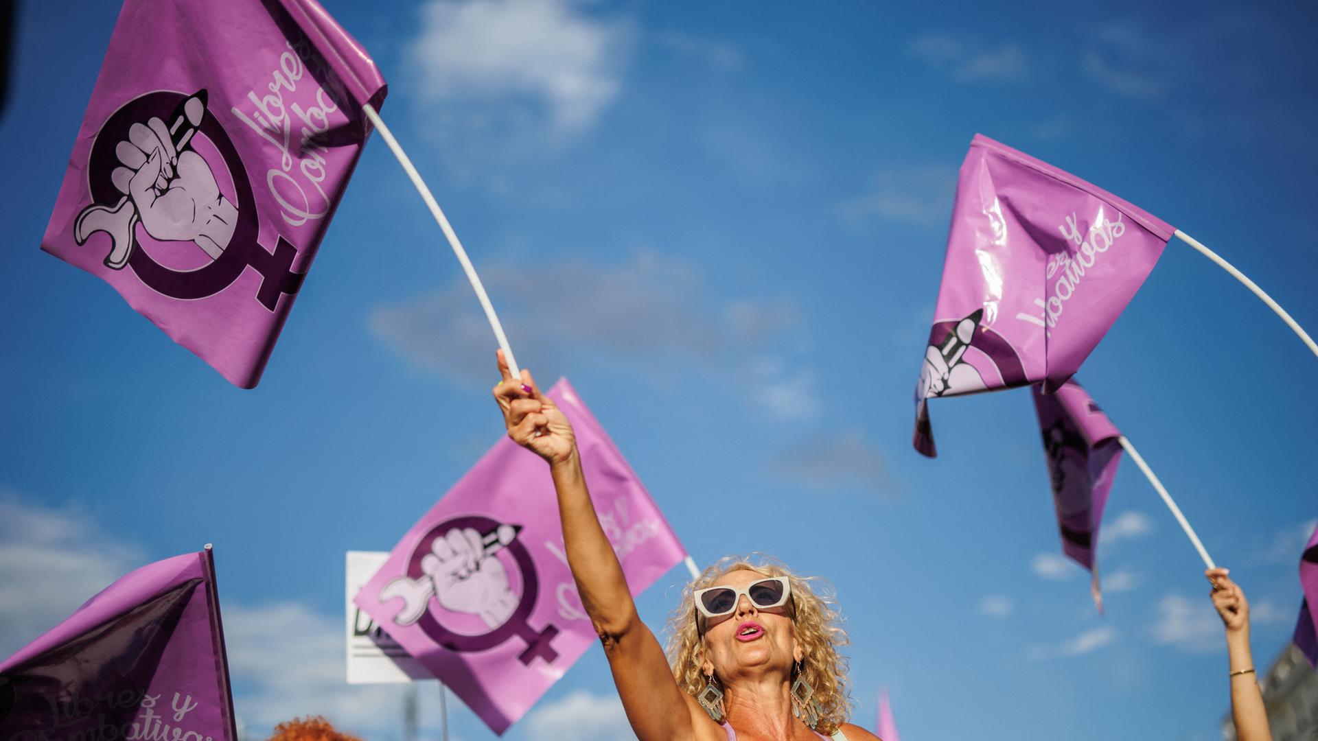 Eine Frau schwenkt auf einer Demonstration gegen den ehemaligen spanischen Fußballfunktionär Rubiales am 1. September 2023 in Madrid eine rosafarbene Fahne mit dem Symbol der Frauenbewegung. 