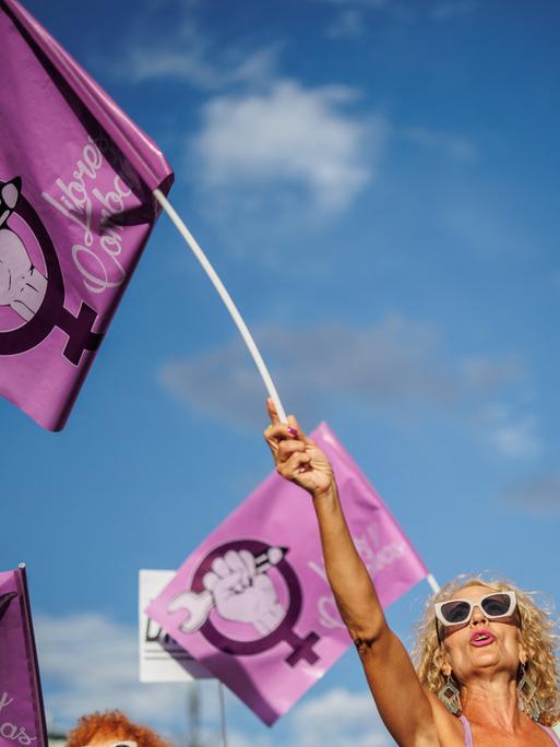 Eine Frau schwenkt auf einer Demonstration gegen den ehemaligen spanischen Fußballfunktionär Rubiales am 1. September 2023 in Madrid eine rosafarbene Fahne mit dem Symbol der Frauenbewegung. 